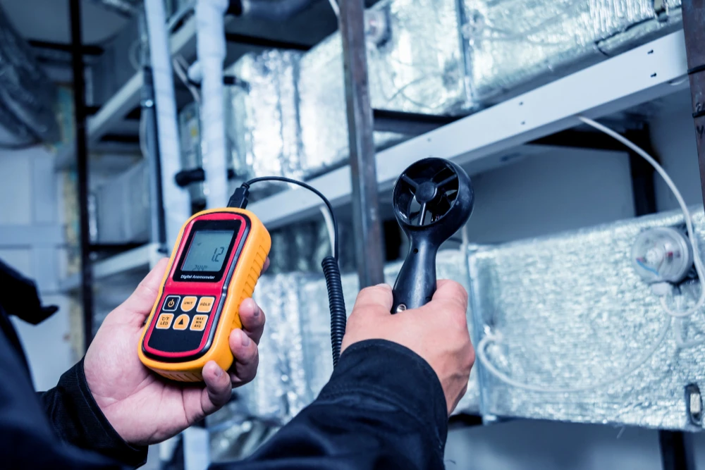 Technician using digital airflow meter